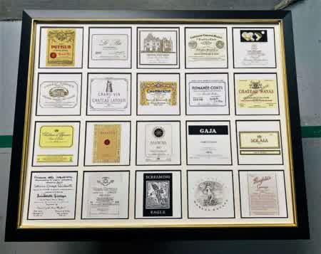 Encadrement décoratif composé de plusieurs étiquettes de grands vins et crus prestigieux, idéal pour décoration murale autour du vin