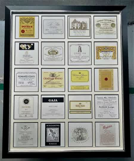 Encadrement décoratif composé de plusieurs étiquettes de grands vins et crus prestigieux, idéal pour décoration murale autour du vin